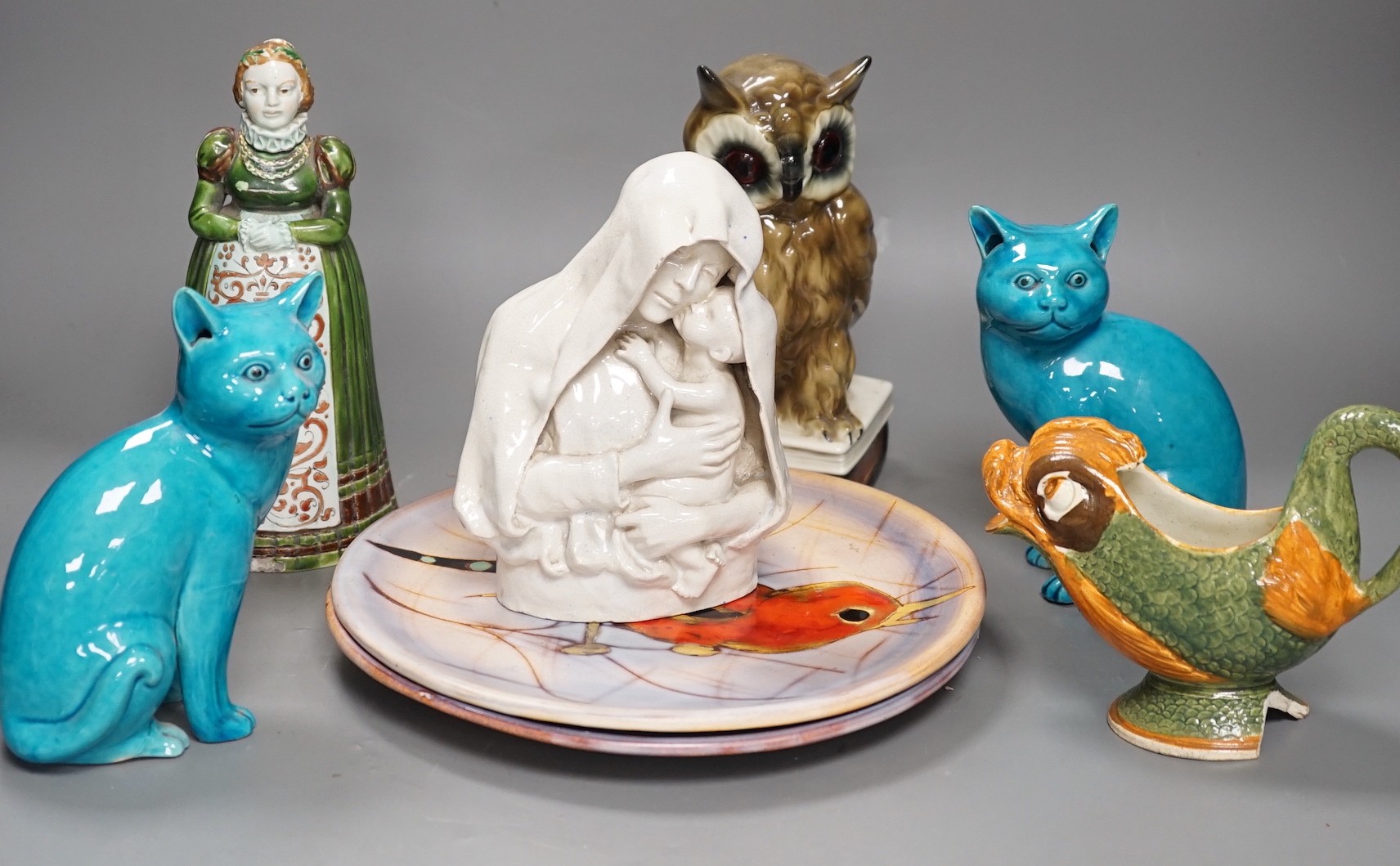 A selection of ceramics, to include two Vallauris plates, a bust of Madonna and child signed ‘Helen Fraser Rock 1925’, a Dutch figure and a pair of turquoise glazed cats etc.